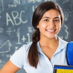 Portrait of pretty Indian high school student in classroom